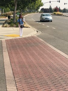 Blind person waiting at the curve preparing to cross the street