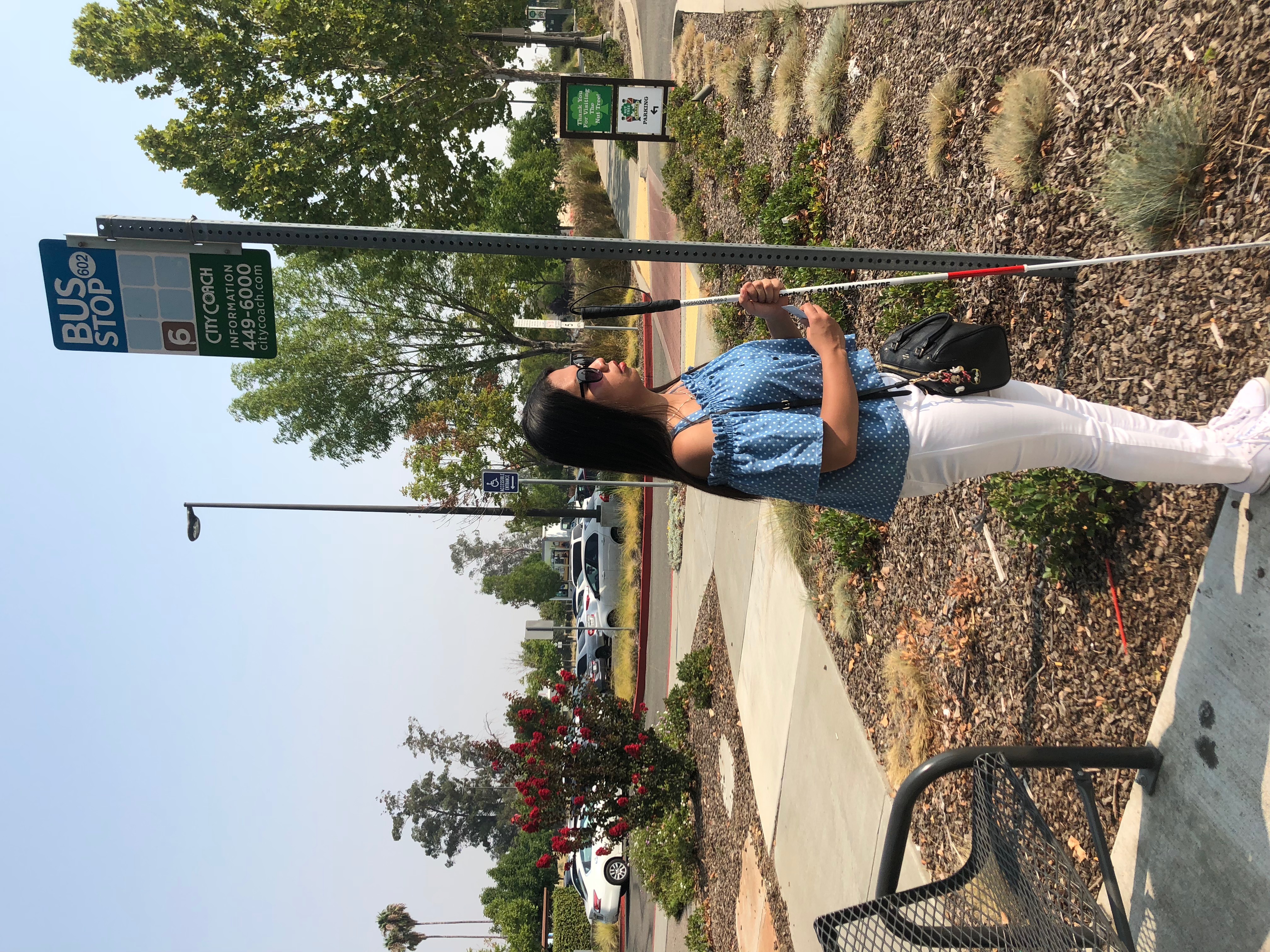 blind on a bus stop for her orientation and mobility training